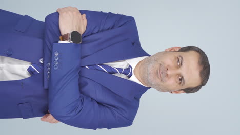 Vertical-video-of-Businessman-with-arms-folded-and-laughing-at-camera.